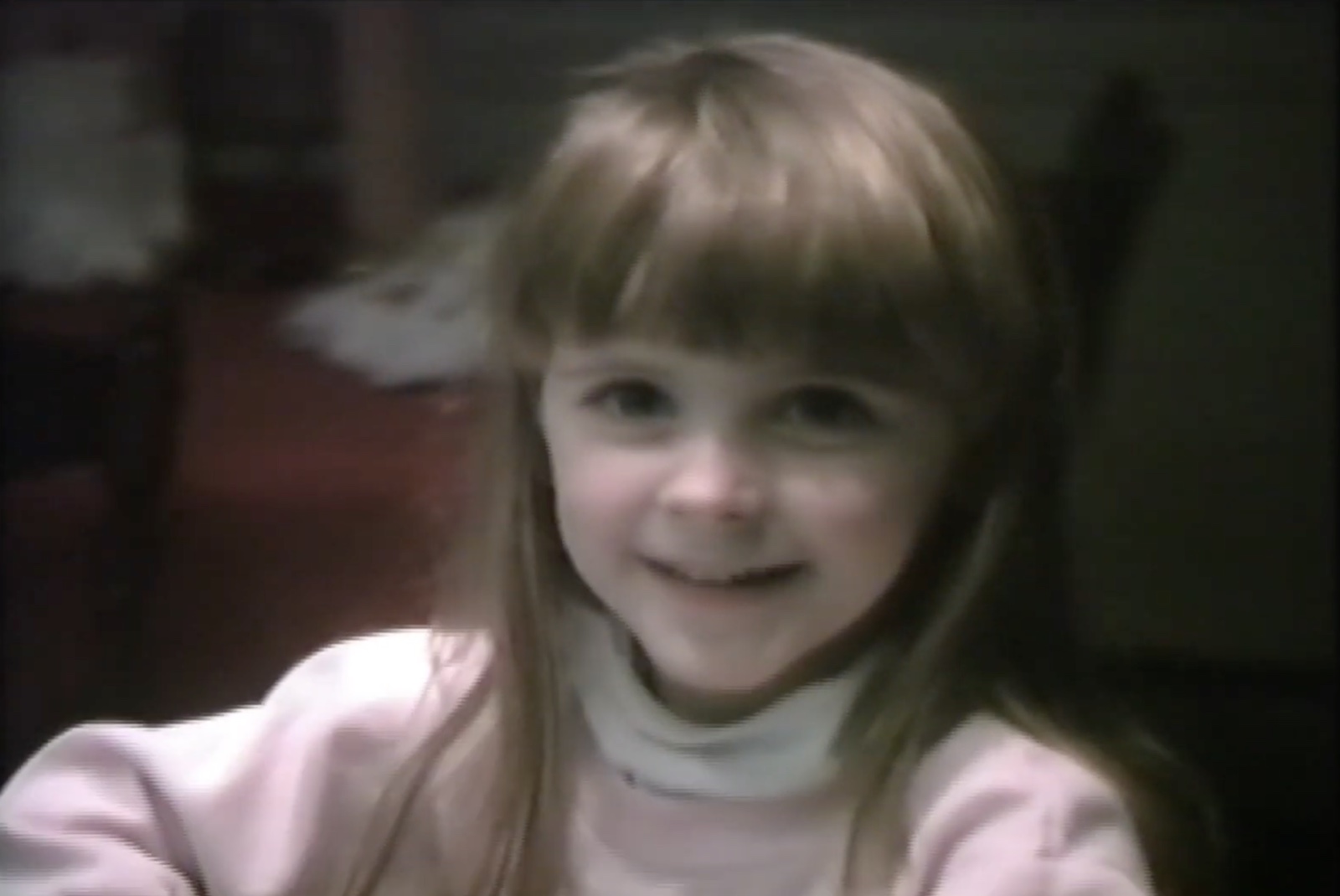 Liz smiling as a child in a still from the Griffith family video archive